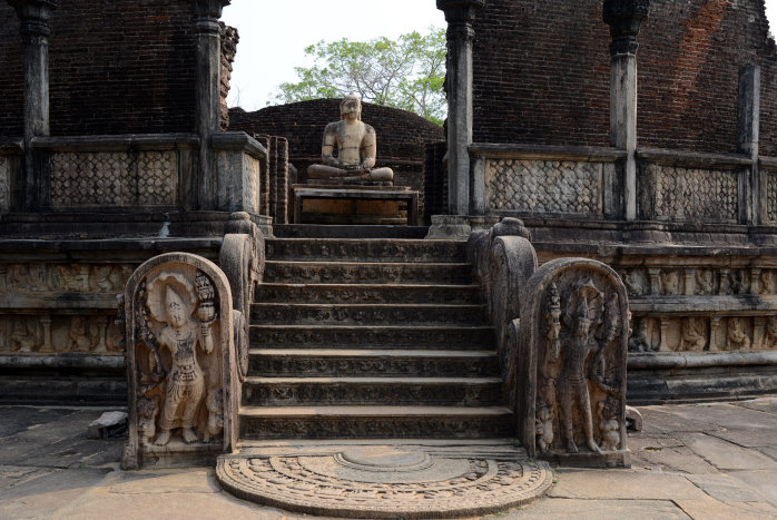 Buddhastatue und typischer Mondstein vor der Treppe